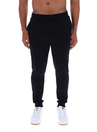 Person wearing black jogger pants on a white background