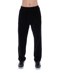 Displays the model wearing the Black 'FILA' branded Lorrie Velour Track Pant