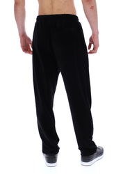 Displays the model wearing the Black 'FILA' branded Lorrie Velour Track Pant