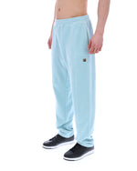 Light blue velour sweatpants with a small FILA logo, worn by a person against a white background