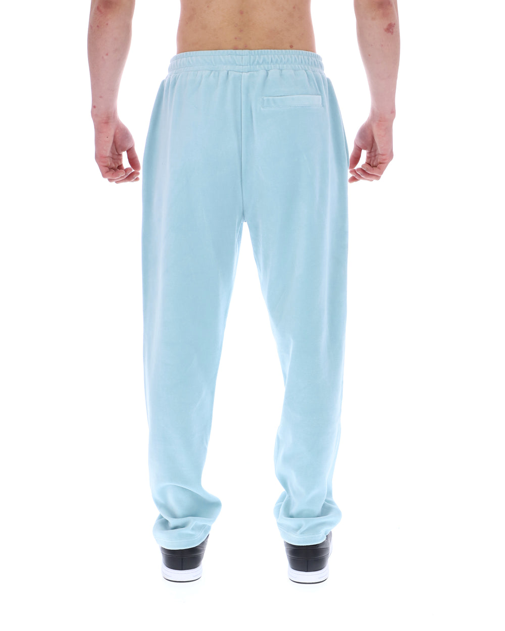 Light blue velour sweatpants worn by a person on a white background