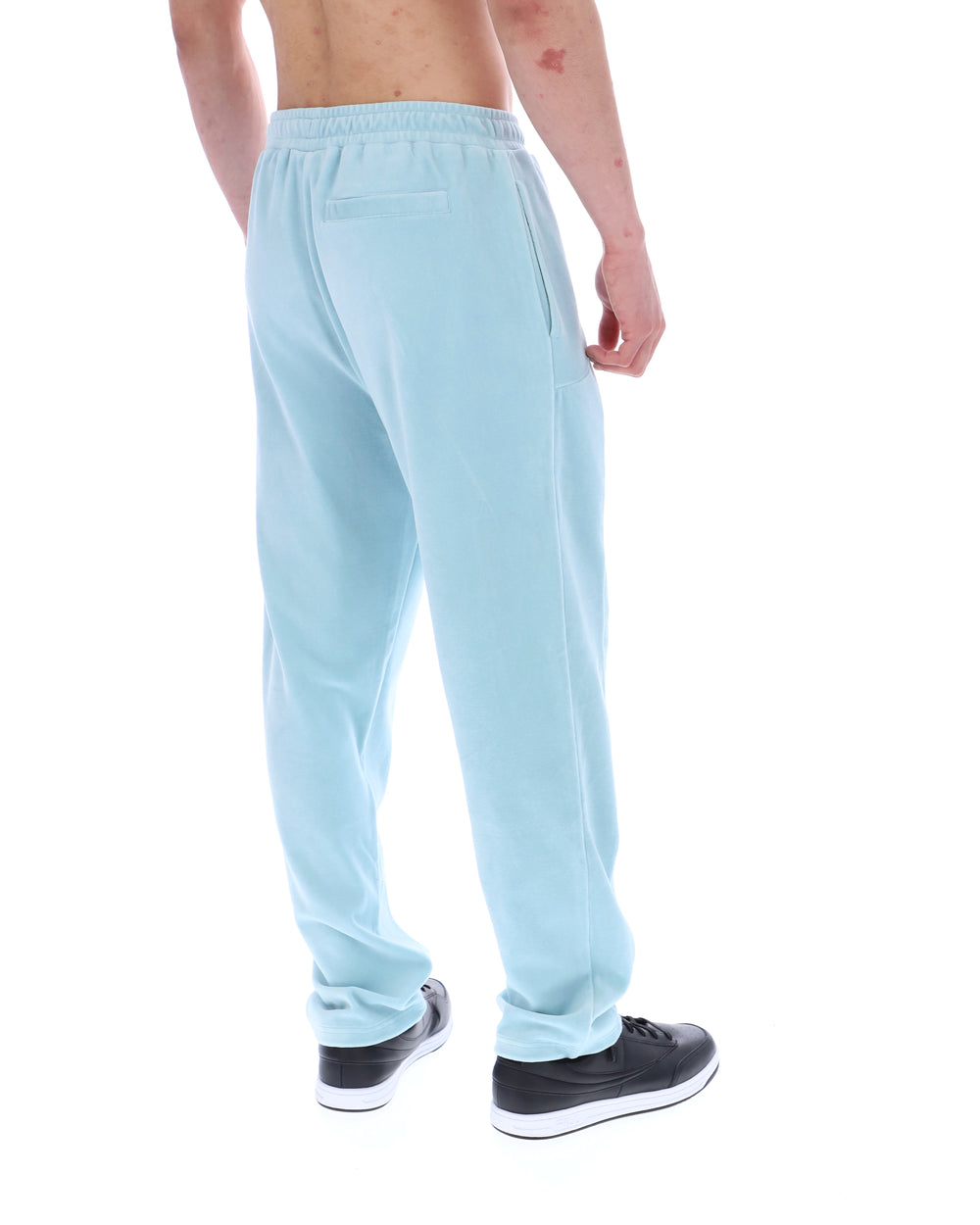 Light blue velour sweatpants worn by a person on a white background