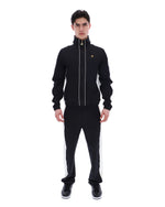 Man wearing a black tracksuit with white stripes on a white background