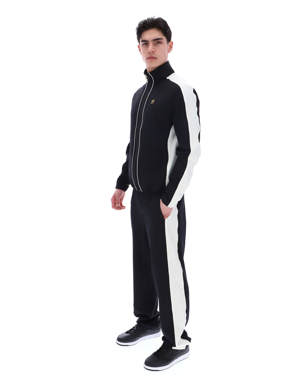 Person wearing a black and white tracksuit on a white background