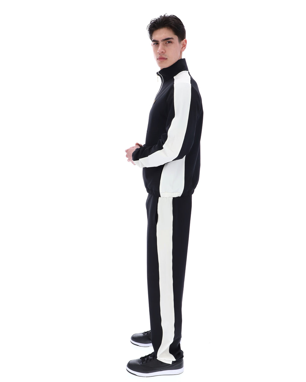 Person wearing a black and white tracksuit on a white background