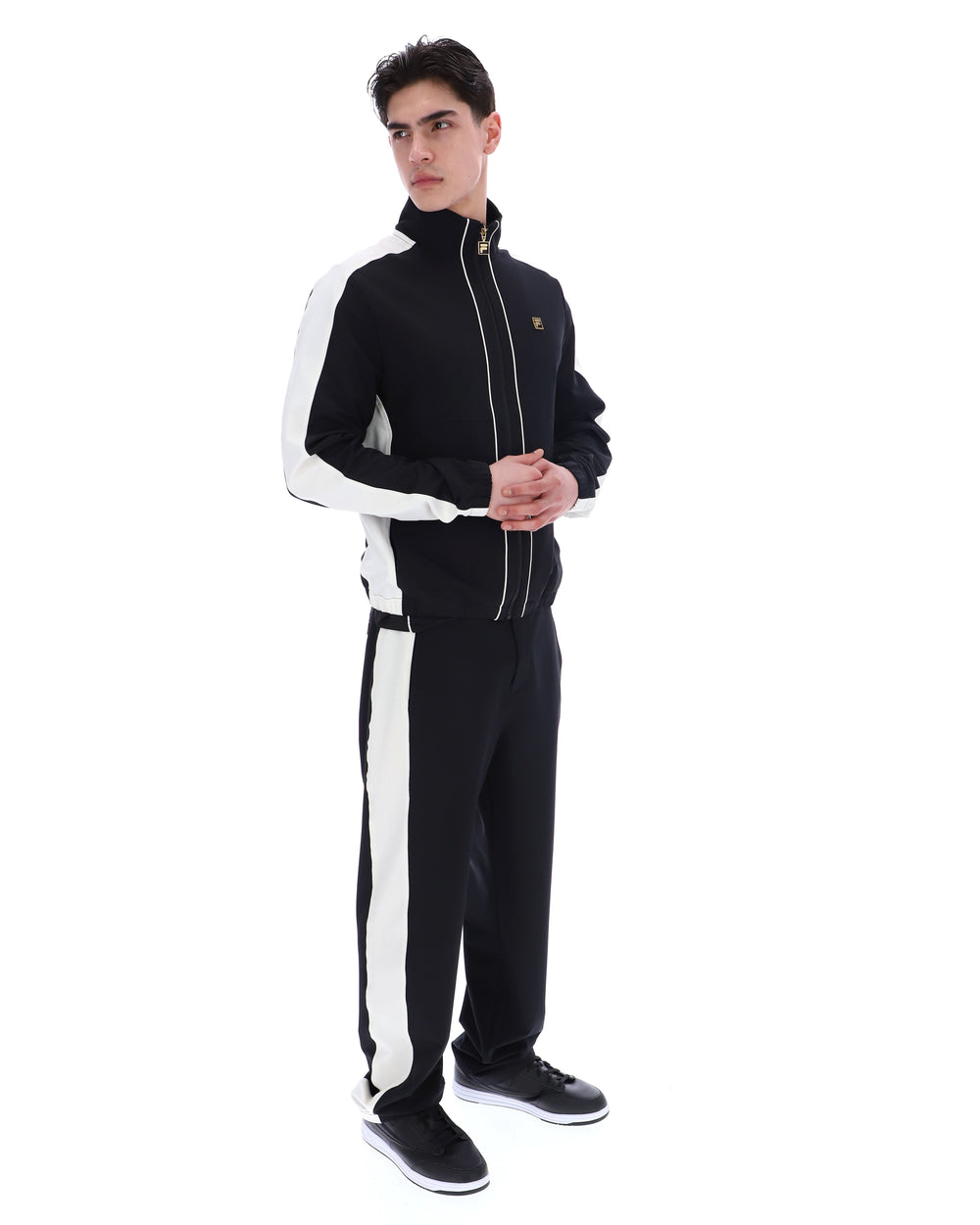 Person wearing a black and white tracksuit on a white background