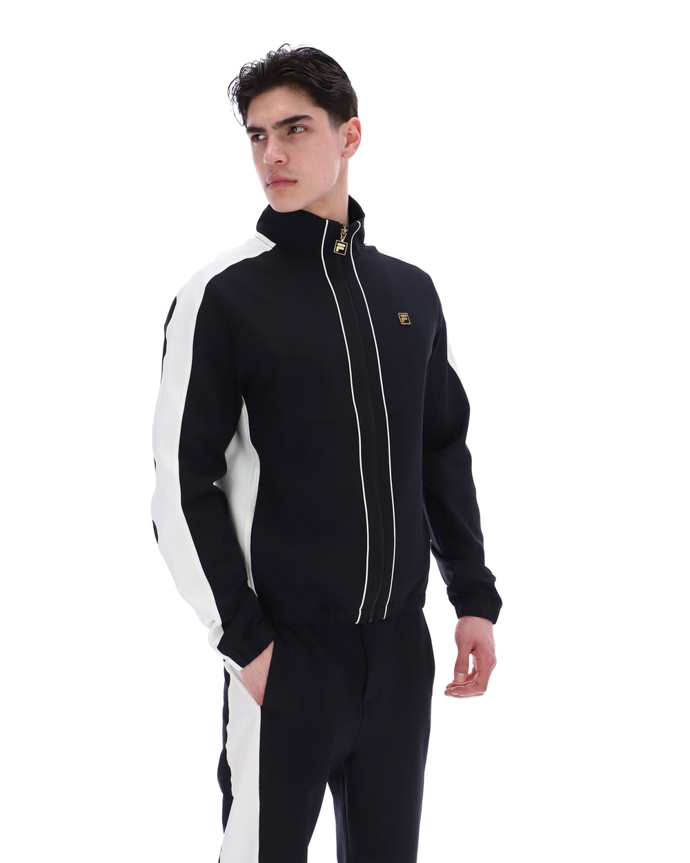 Man wearing a black and white tracksuit with a brand logo on a white background