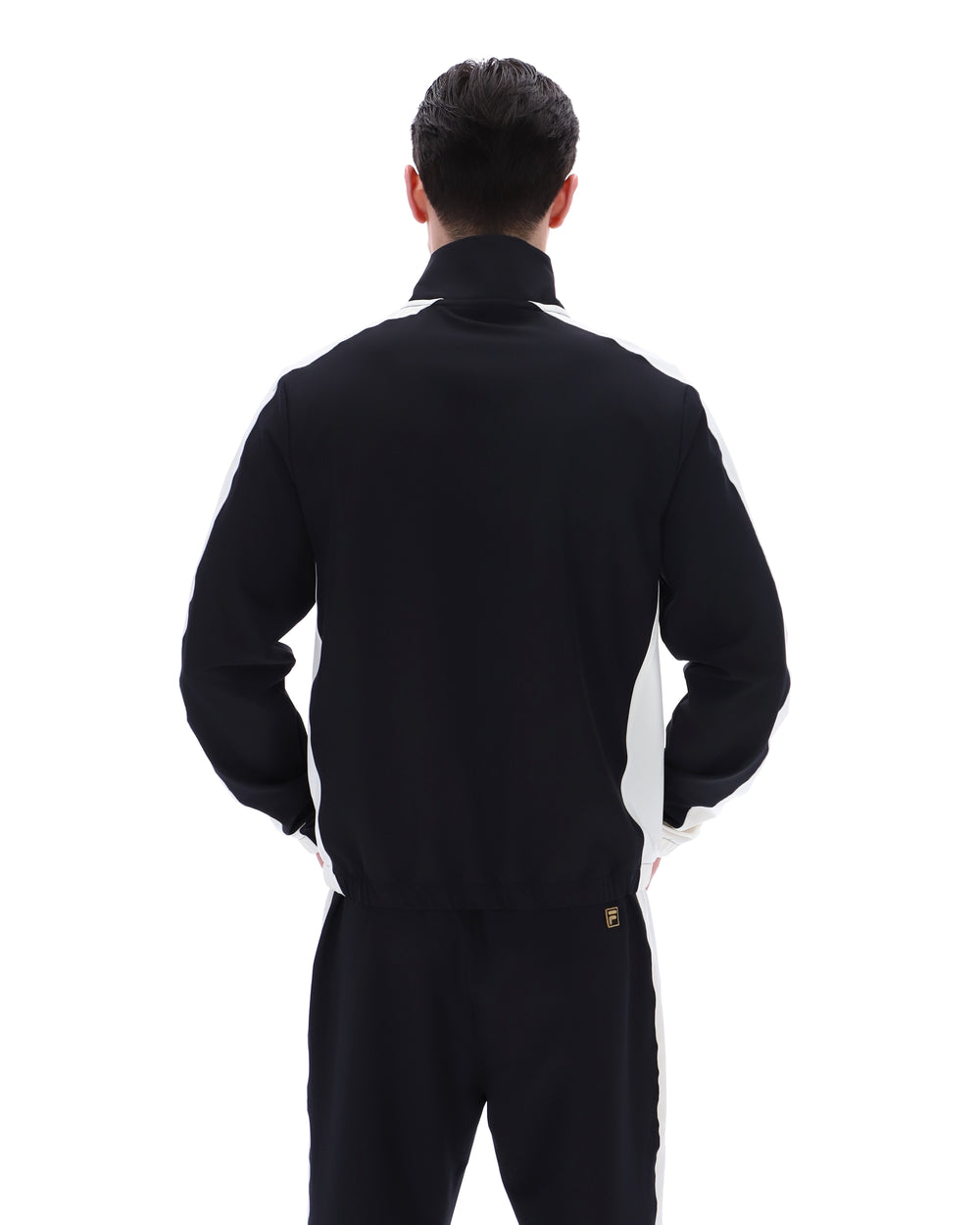 Person wearing a black tracksuit with a brand logo on a white background