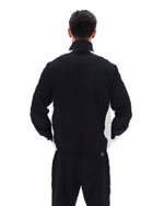 Person wearing a black tracksuit with a brand logo on a white background