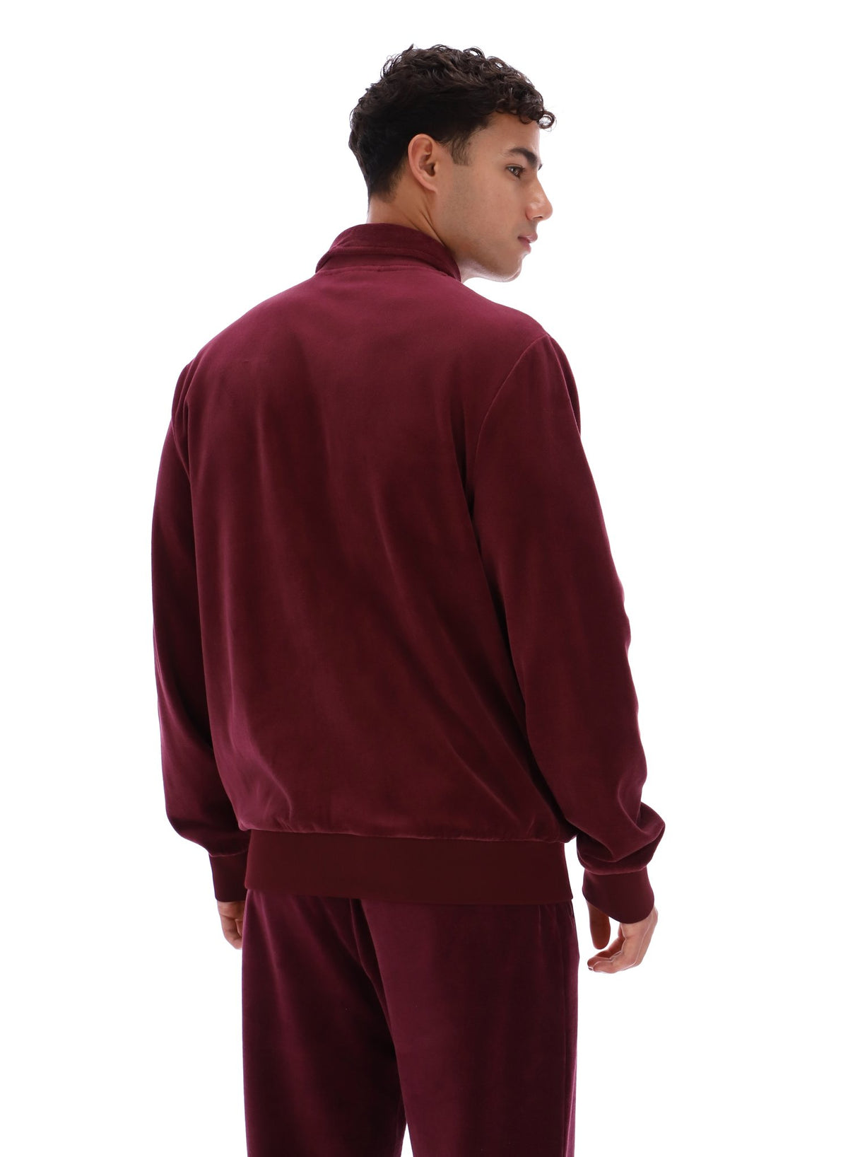 Person wearing a burgundy tracksuit jacket and bottoms on a white background