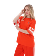 Woman wearing an Orange t-shirt with '1911' text and white stripes on sleeves, FILA logo on chest, on a white background
