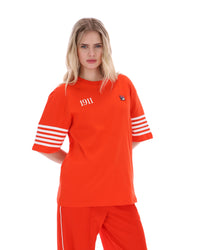Woman wearing an Orange t-shirt with '1911' text and white stripes on sleeves, FILA logo on chest, on a white background