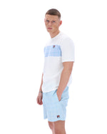 Man wearing a white and light blue color-blocked shirt with matching shorts on a white background