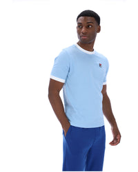 Man wearing a light blue t-shirt with white trim and blue pants on a white background