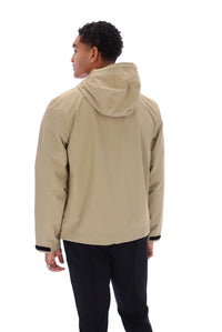 A man shown from the back wearing a light beige hooded jacket and black pants, photographed against a plain white studio background.