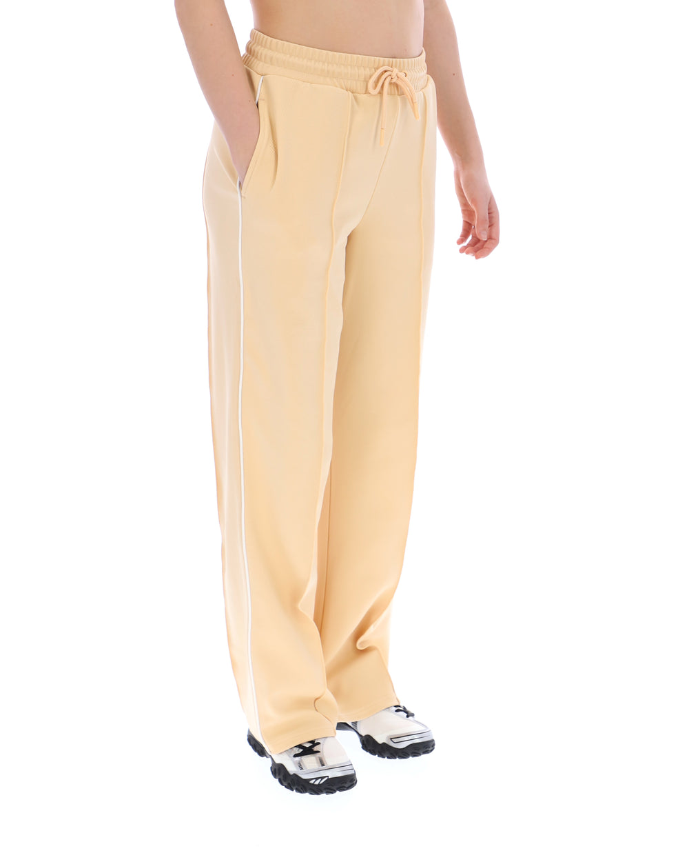 Person wearing light yellow sweatpants on a white background