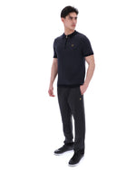Man wearing a black polo shirt and pants with a logo on a white background