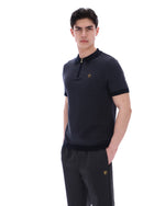 Man wearing a black polo shirt and pants with a brand logo on a white background