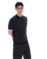 Man wearing a black polo shirt with a collar on a white background
