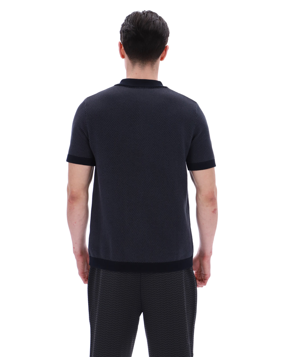 Man wearing a black polo shirt and pants on a white background