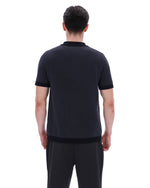 Man wearing a black polo shirt and pants on a white background