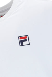 White tennis t-shirt with cap sleeves, featuring the FILA logo and a Union Jack flag patch on the chest.