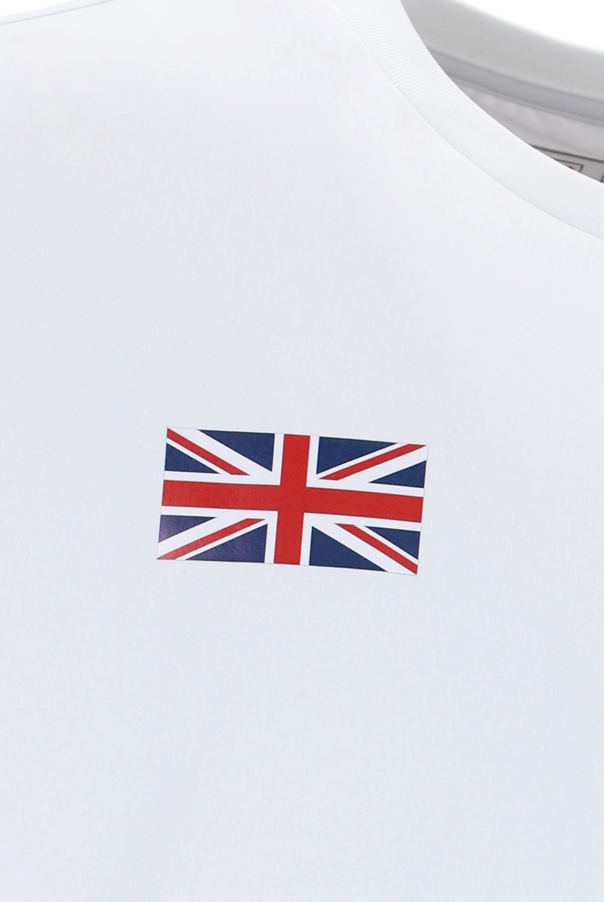 White tennis t-shirt with cap sleeves, featuring the FILA logo and a Union Jack flag patch on the chest.