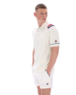 Man wearing a white polo shirt with a FILA logo on the sleeve, on a white background