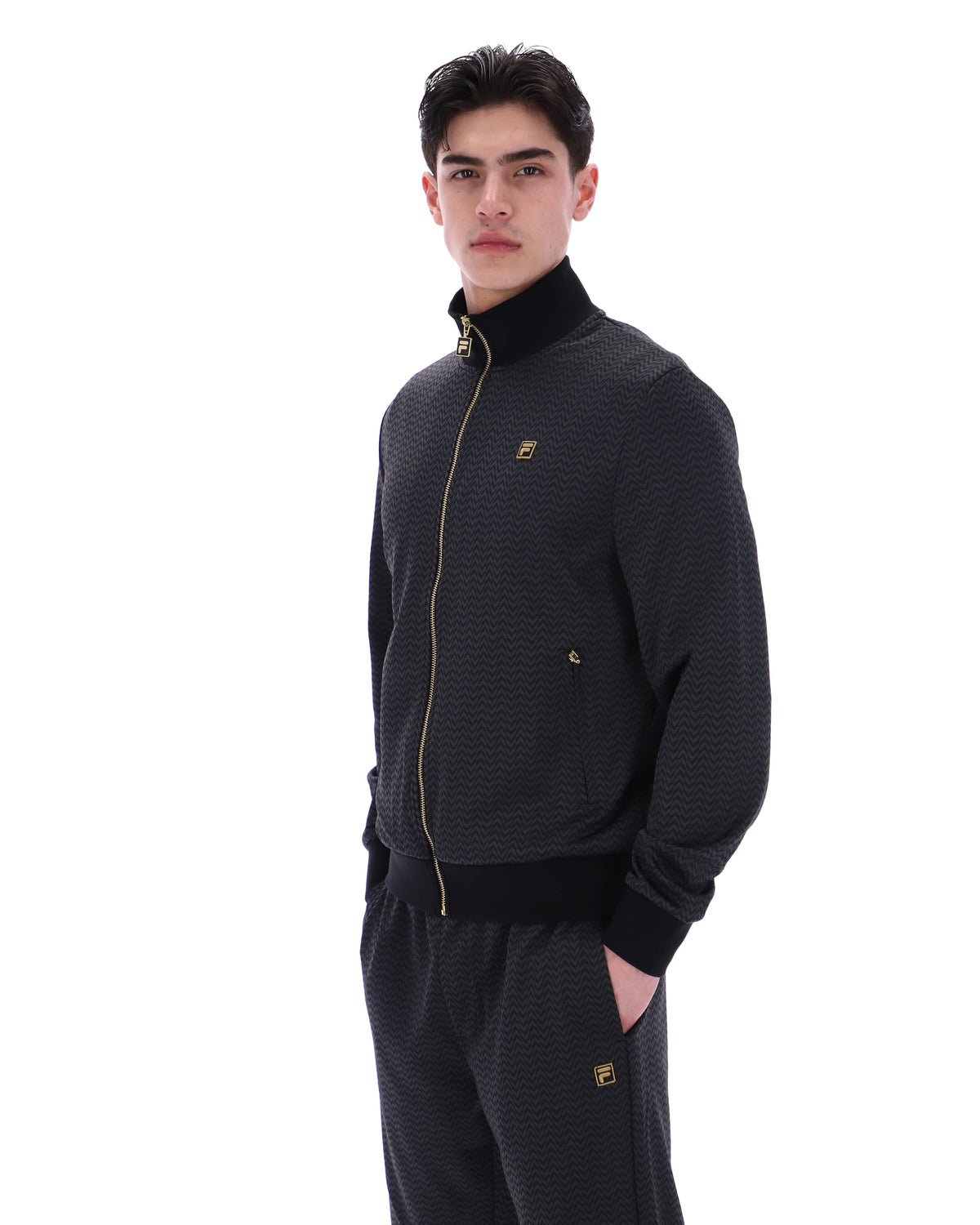 Displays a model wearing the Black 'FILA' branded Mathers Herringbone Track Top