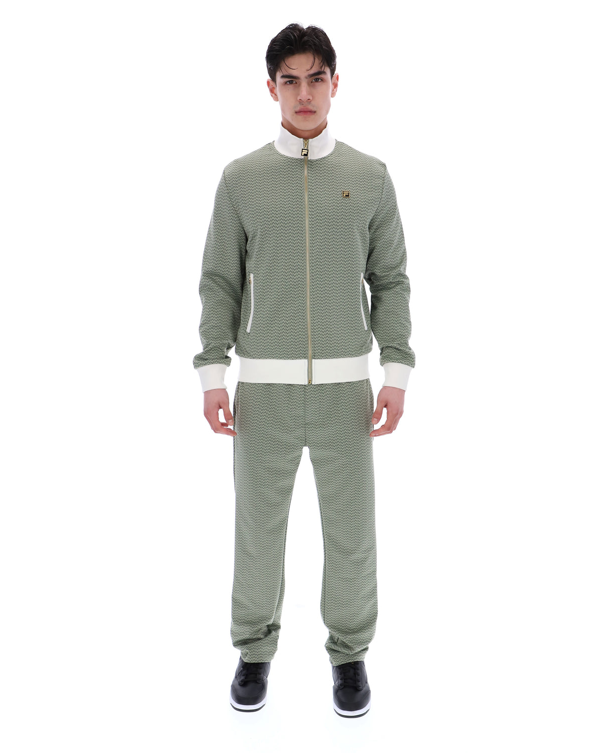 Displays a model wearing the Sea Foam 'FILA' branded Mathers Herringbone Track Top