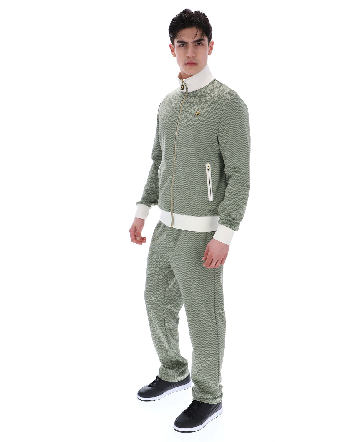 Displays a model wearing the Sea Foam 'FILA' branded Mathers Herringbone Track Top