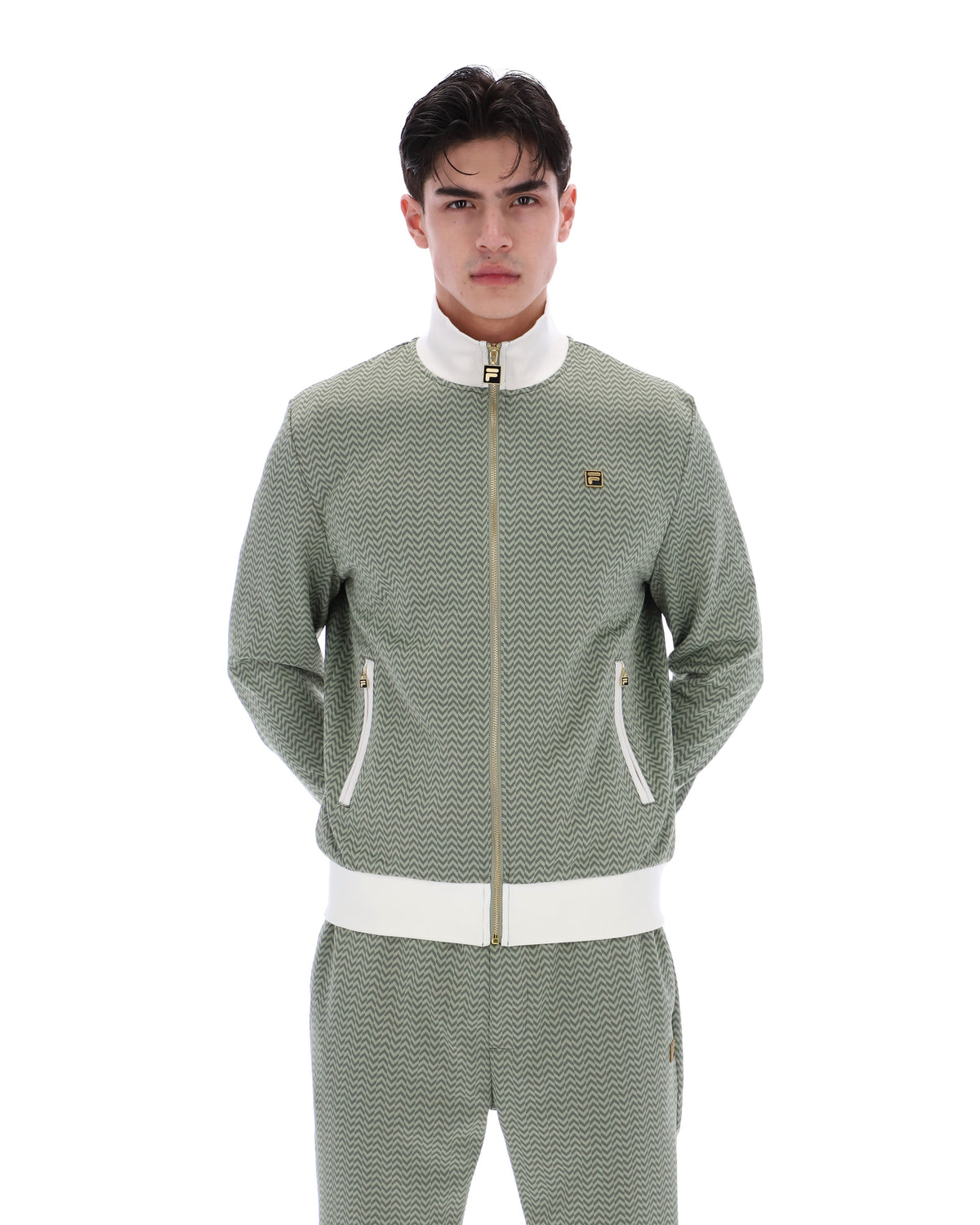 Displays a model wearing the Sea Foam 'FILA' branded Mathers Herringbone Track Top
