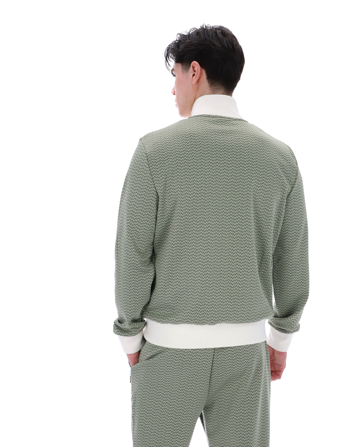 Displays a model wearing the Sea Foam 'FILA' branded Mathers Herringbone Track Top