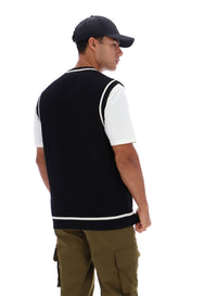 Displays a model wearing the Black 'FILA' branded Mellor Textured Knit Vest with Tipping