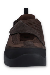 Brown flat shoe with a strap on a white background
