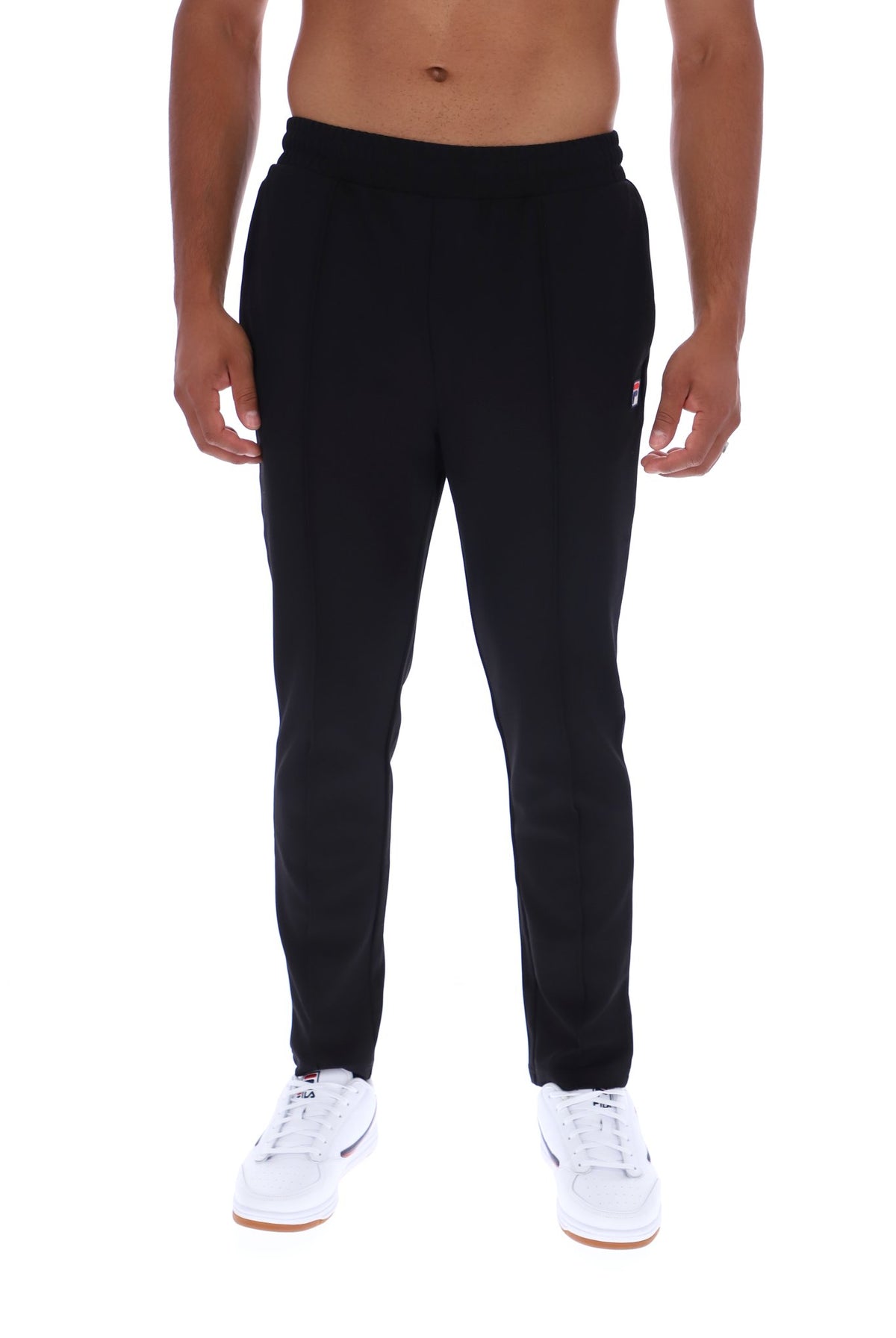 A man wearing black sweatpants and white sneakers, shown from the waist down against a plain white background.