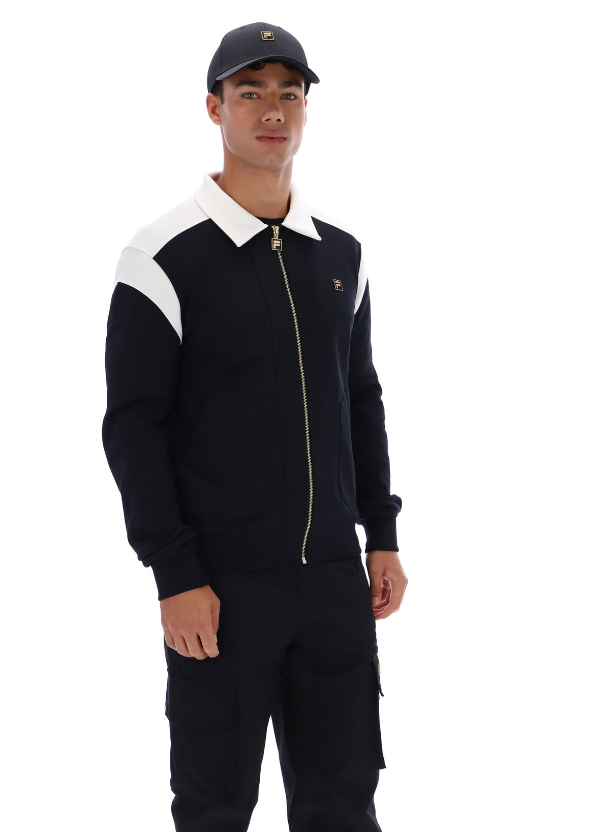 Man wearing a black and white jacket with a cap on a white background