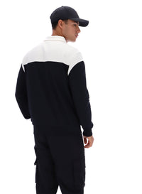 Person wearing a black and white jacket with a cap on a white background