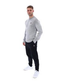Displays a model wearing the Gardenia 'FILA' branded Noah Knitted Crew Neck