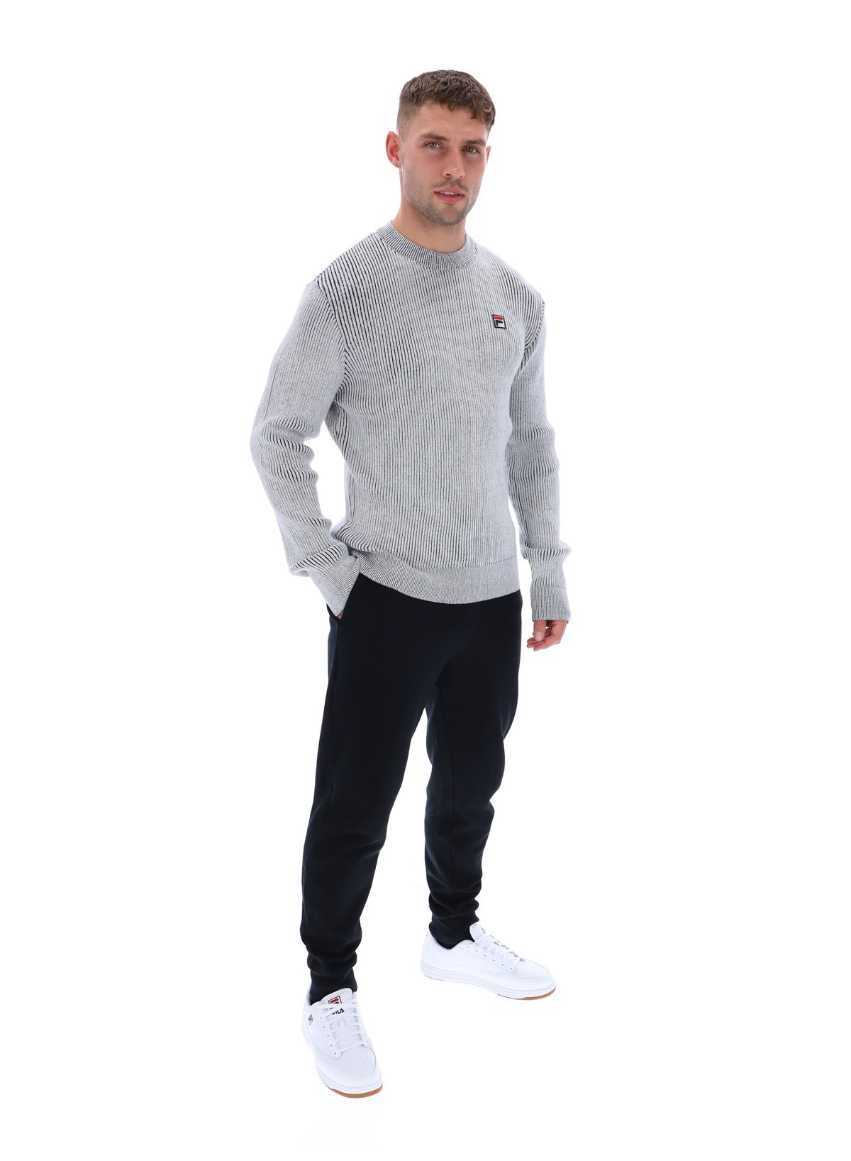 Displays a model wearing the Gardenia 'FILA' branded Noah Knitted Crew Neck