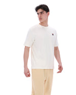 Man wearing a white t-shirt with a small logo on a white background