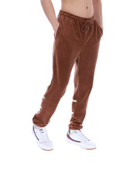 Brown sweatpants worn by a person on a white background