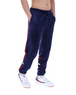 Navy blue jogger pants with red accents worn by a person on a white background