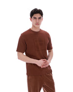 Man wearing a brown t-shirt and pants on a white background