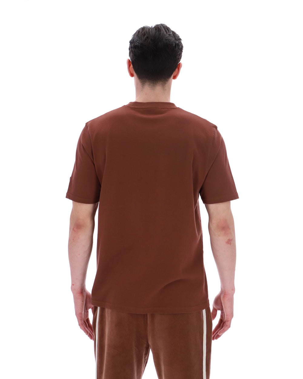 Person wearing a brown t-shirt and pants on a white background
