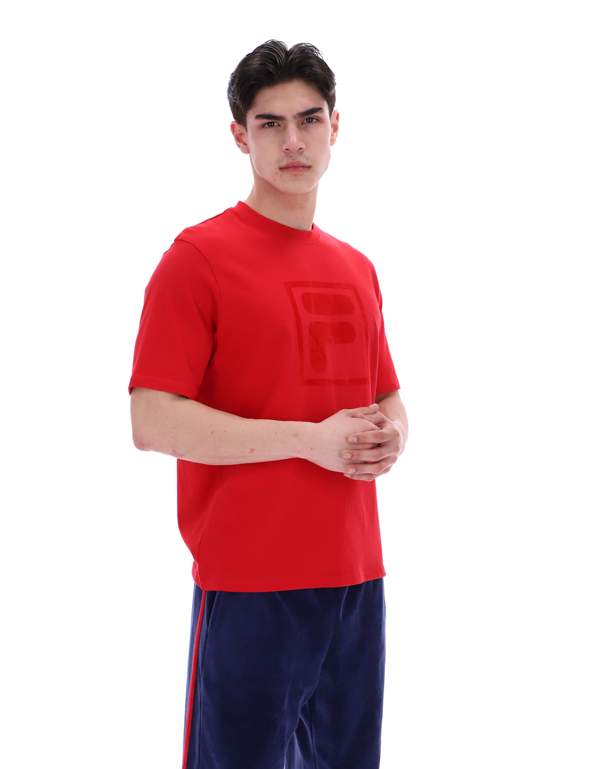 Person wearing a red t-shirt with a logo on a white background