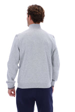 A man viewed from behind wearing a light gray heathered mock-neck sweatshirt and navy blue pants, set against a plain white background.