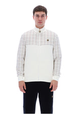 A man wearing a color-blocked zip-up jacket with a white and beige plaid upper chest and sleeves, and a solid white lower body, paired with black pants, against a plain white background.