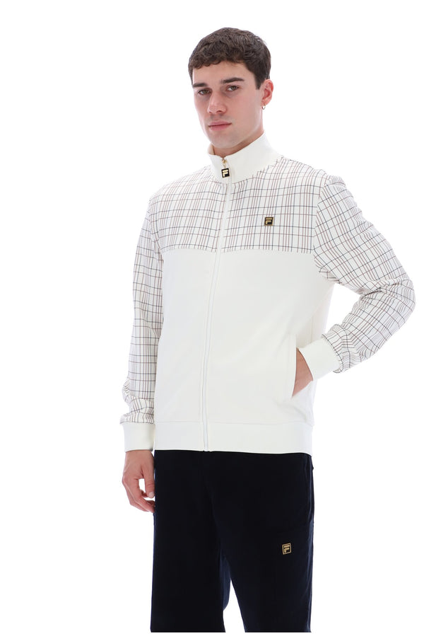 A man wearing a white and beige plaid zip-up jacket with a high collar and black pants, standing against a plain white background.