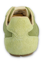 Rear view of a FILA Ritmo trainer in green suede, showcasing the pale green textured, hairy suede heel counter with detailed curved stitching and a cream padded collar against a white background.